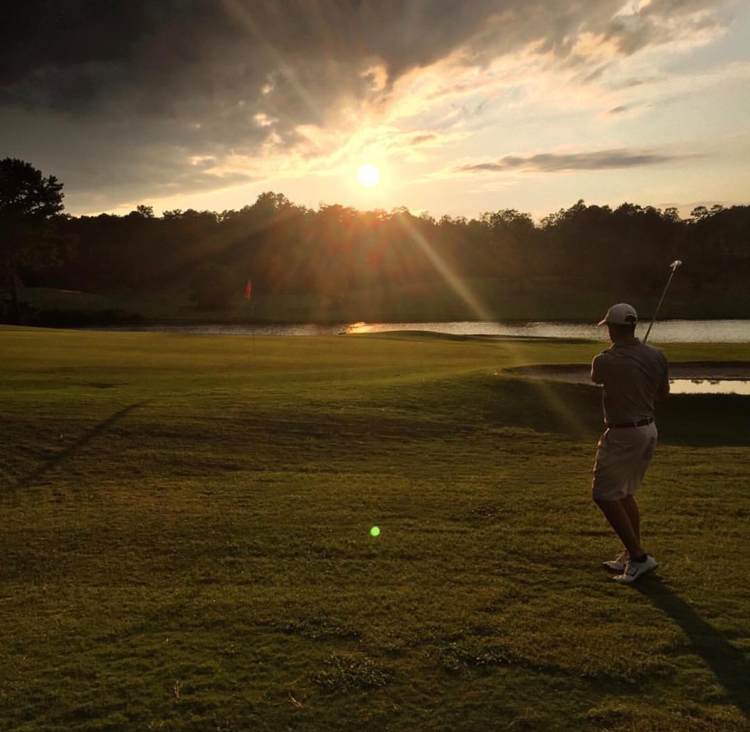 Golfer playing at sunset